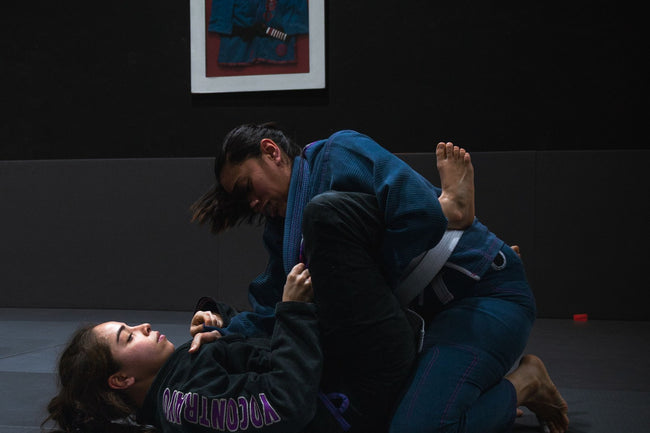BJJ practitioners training in a gym interior