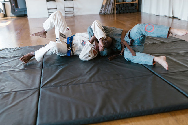 BJJ practitioners training with control on the mat